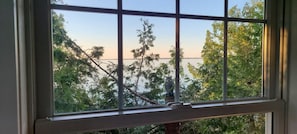 Una ventana con vistas a árboles y una masa de agua.