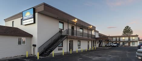 Un motel Days Inn con una estructura de dos pisos, un estacionamiento y una escalera visible que conduce a la entrada.