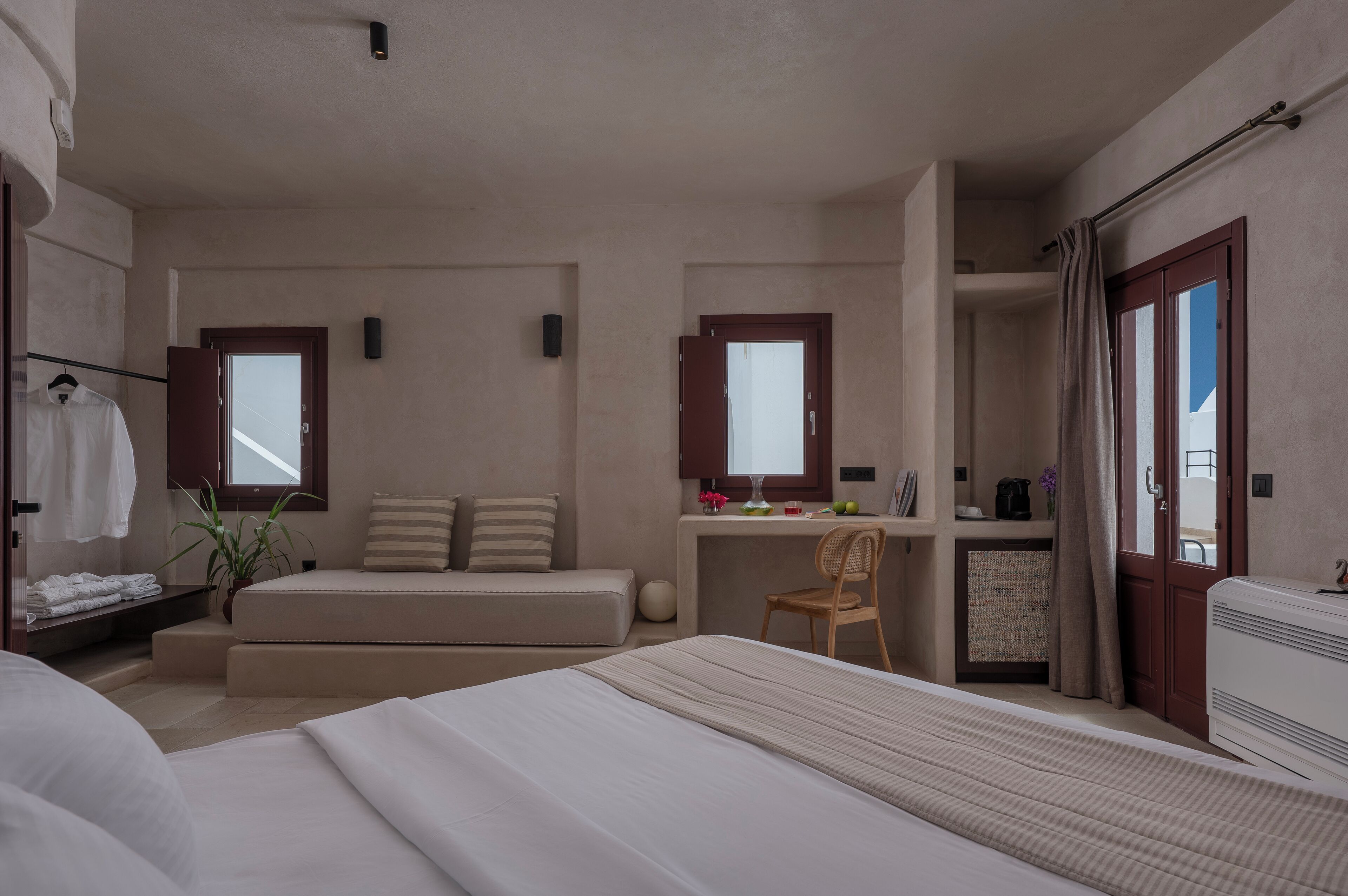 A hotel room with a bed, a desk, a chair, a wardrobe, and a bathroom.