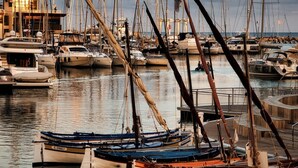 A marina with multiple boats docked, a building with a flag, and a cloudy sky. - Apartment 4 guests with access to the beach/Fréjus (Fréjus)