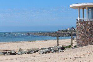 A beach with a stone lookout tower, rocky shoreline, and a clear view of the ocean. - Maison vue sur mer Dans les Dunes Sans Voitures (Bretignolles-sur-Mer)