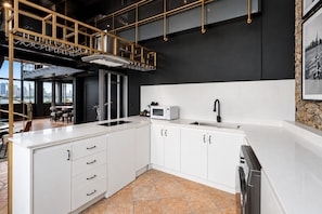 A modern kitchen with white cabinetry, a stainless steel sink, and a black faucet. - Penthouse deluxe, 360º views and glass pool (Ciudad de Panamá)