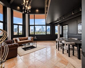 A modern living room with a sofa, coffee table, and dining area, featuring large windows with a city view. - Penthouse deluxe, 360º views and glass pool (Ciudad de Panamá)