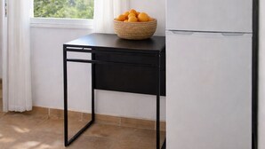 A kitchen with a white refrigerator, a black table, and a basket of oranges on the table. - Grand Seaview Retreat - walk to the beach (Thessaloniki)