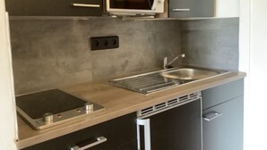 A modern kitchen with a microwave, sink, and built-in oven. - Pieds dans l'eau Secret Creek (Conca)