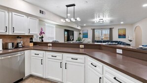 A modern kitchen with white cabinets, a brown countertop, and a pendant light. - Get Together & Stay-Play-Relax! Peaceful Oasis w/ TVs, Games, & BBQ -LUCKY House (Houston)