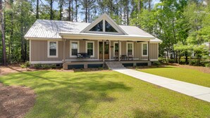A two-story house with a gabled roof, a front porch with seating, and a well-maintained lawn. - Spacious Midway Cottage w/ Porches, Near Hunting! (Midway)