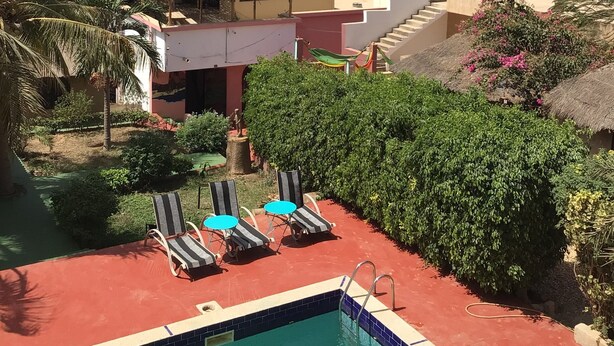 A pool area with lounge chairs and a view of the sea.