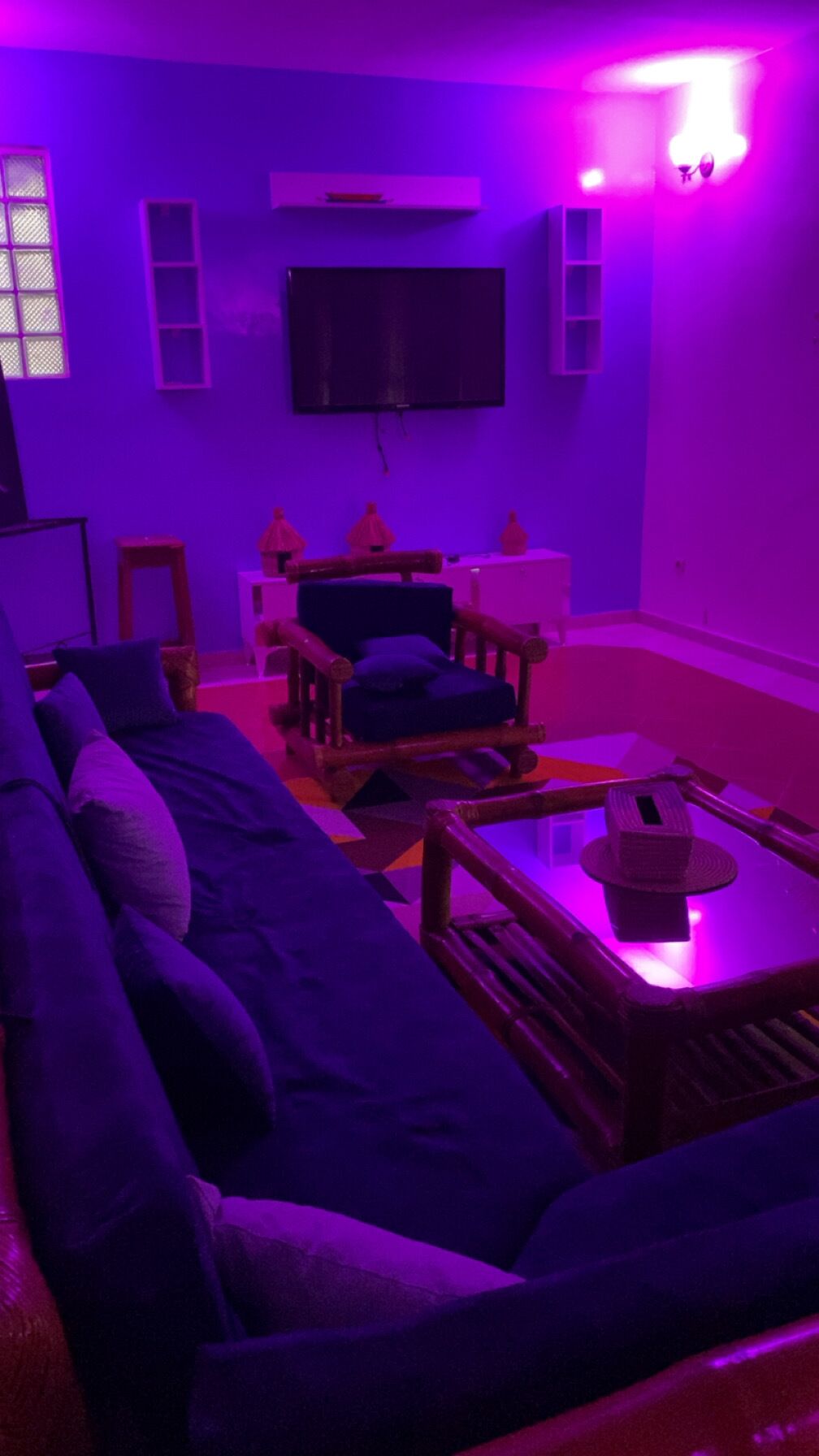 A living room with a sofa, a coffee table, and a television.