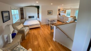 A compact, modern apartment with a bed, a dining area, and a kitchenette.
