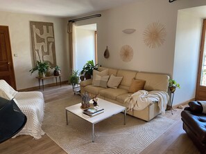 Un salon avec un canapé, une table basse et des plantes en pot.