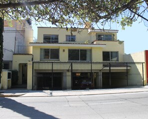 A two-story building with a gated entrance and a visible vehicle inside.
