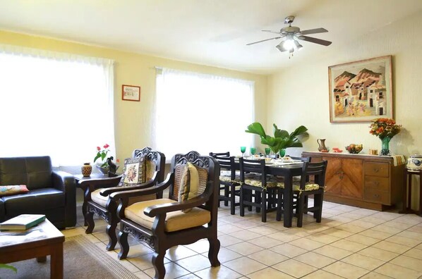A dining area with a round table, chairs, and a ceiling fan.