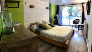 A bedroom with a wooden bed, a green wall, and a view of the outdoors. - Maison, Piscine Privée et Terrain de Boules, au Calme (Trévoux)