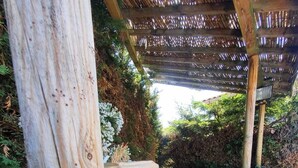 A wooden deck with a stone planter and a pergola structure. - Maison, Piscine Privée et Terrain de Boules, au Calme (Trévoux)