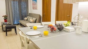 Una cocina moderna con una isla grande, comedor y un sofá.
