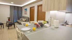Una cocina moderna con una isla central, un comedor con sofá y una sala de estar con sofá.