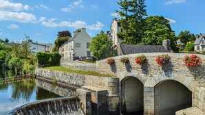 A stone bridge with flower pots and a canal. - 1 bedroom lovely home in Lannéanou (Lannéanou)