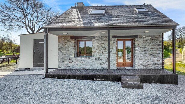 A modern house with a stone facade, a wooden deck, and a small garden area. - 1 bedroom lovely home in Lannéanou (Lannéanou)