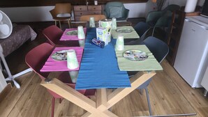Een eettafel gedekt met borden, bekers en een pak melk.