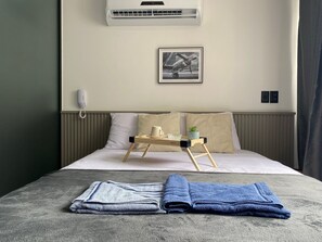 A neatly made bed with a tray, pillows, and a framed picture on the wall. - Bela Hospedagem - Get One Bessa (João Pessoa)