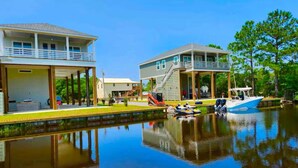 A waterfront property with two houses, a dock, and a boat. - Boating, Fishing, Kayaking and more at this NEW Waterfront Bay St. Louis Retreat (Bay St. Louis)