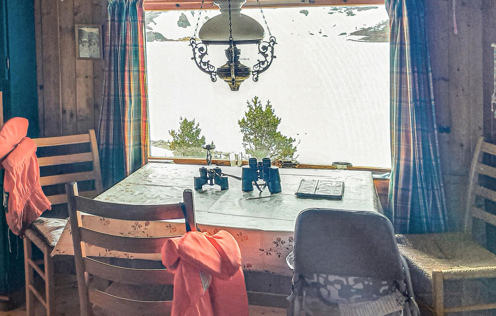 A dining area with a table, chairs, and a view of a lake.