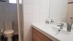 Un baño con inodoro, lavamanos y espejo.