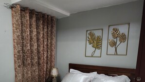 Un lit bien fait, avec du linge de lit blanc, une tête de lit en bois et une table de chevet avec une lampe.