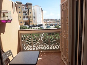 Enjoy the view from this balcony with a gate and seating area.