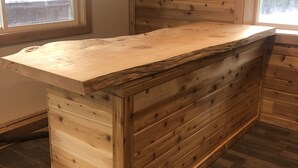 A wooden bar area with a built-in sink and a window providing natural light. - Rocky Mountain Getaway (Plains)