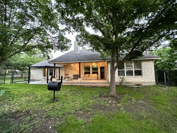 A house with a covered patio, a lawn, and a mailbox.