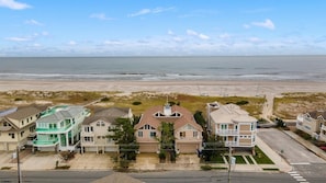 Uma área residencial costeira com casas, uma praia e céu claro.