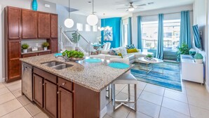 A modern kitchen with granite countertops, a built-in dishwasher, and a central island with a sink. - Retreat 5 Bed Townhouse screened Private Pool*Amazing price (Davenport)