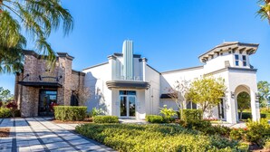 A fitness center with a modern design, featuring a brick facade, a central glass entrance, and a landscaped garden area. - Retreat 5 Bed Townhouse screened Private Pool*Amazing price (Davenport)