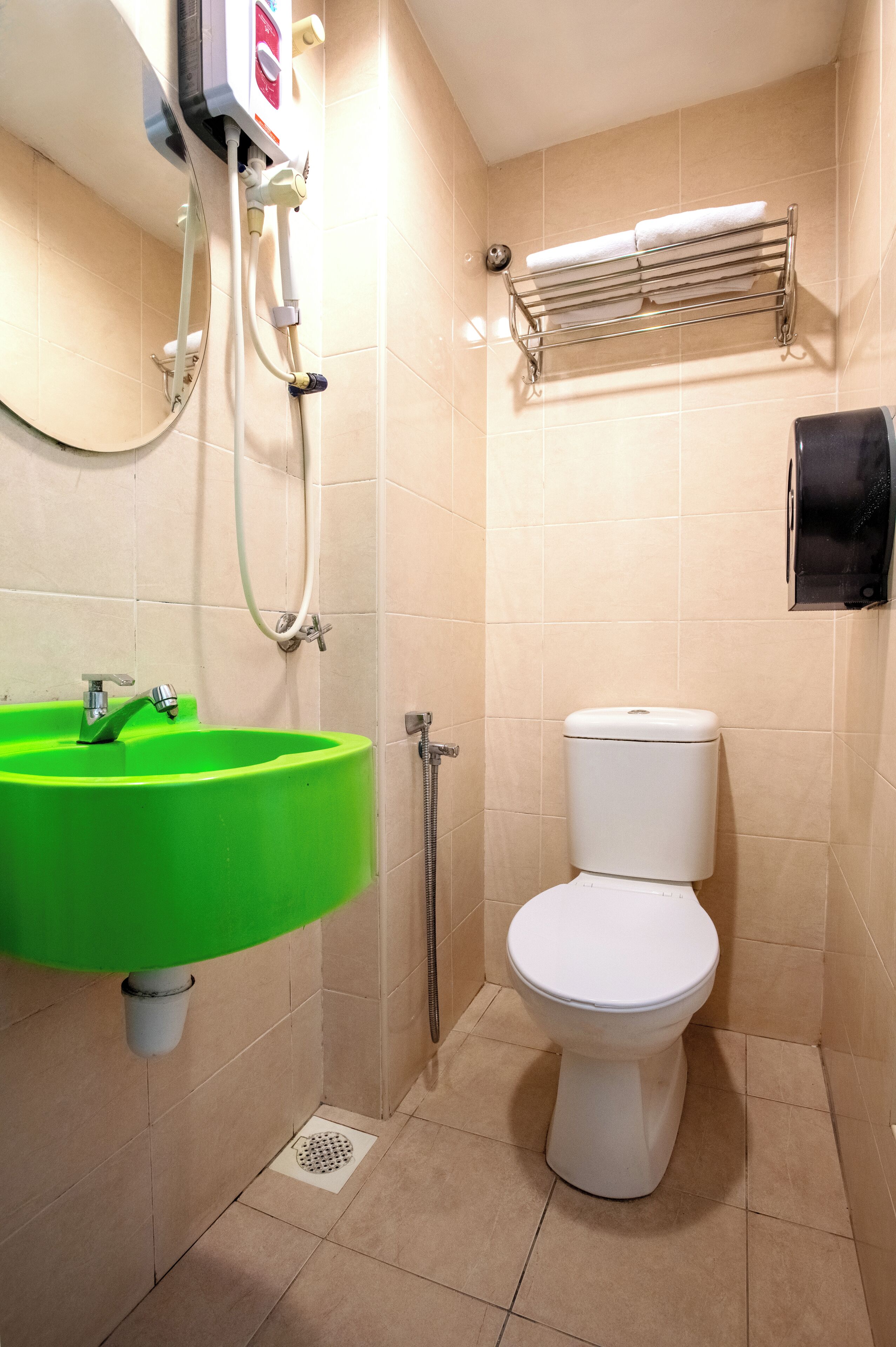 Une salle de bain avec un lavabo vert, des toilettes blanches et un porte-serviettes.