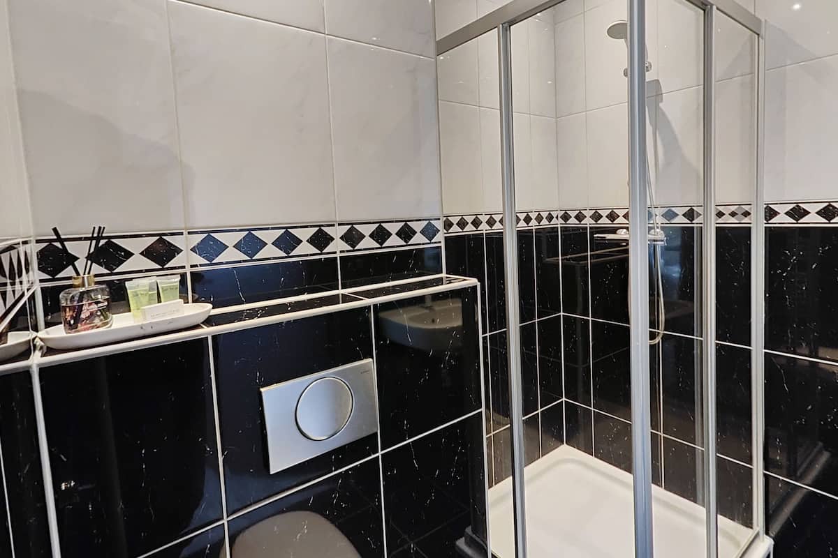 Une salle de bain moderne avec une douche à parois de verre, un meuble-lavabo avec un miroir et un évier.