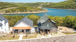 Zona residencial con tres casas, un estacionamiento y un lago.