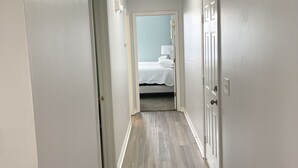 Un pasillo estrecho con una cama al fondo.