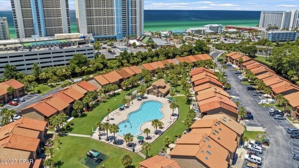 A resort with a central swimming pool, multiple hotel buildings, and a view of the ocean. - Siren’s Call, with only a 4 min walk to the beach, is truly irresistible!  (Panama City Beach)