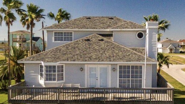 Une maison à deux étages avec un porche et un garage.