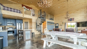 Ein großzügiger Loft-Innenraum mit Küche, Essbereich und einer Treppe zu einer erhöhten Ebene.