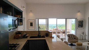 Una cocina moderna con una isla central, un comedor con vistas y una zona de estar acogedora.
