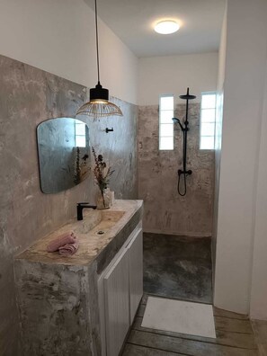 Een douche, handdoeken, zeep, toiletpapier