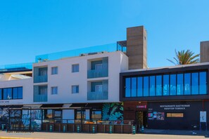 Ein modernes Gebäude mit mehreren Etagen, einer Dachterrasse und einem Restaurant namens 'Restaurante Gastrobar'.
