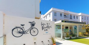 Un edificio con un cartel que anuncia Endorphin Club Road y una pared cercana con una bicicleta y la frase 'La vida es un hermoso viaje'.