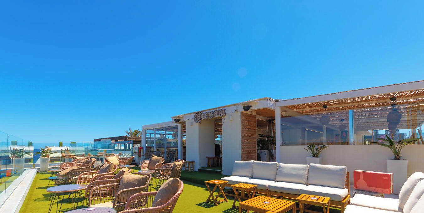 A rooftop terrace with outdoor seating, a pool, and a view of the ocean.