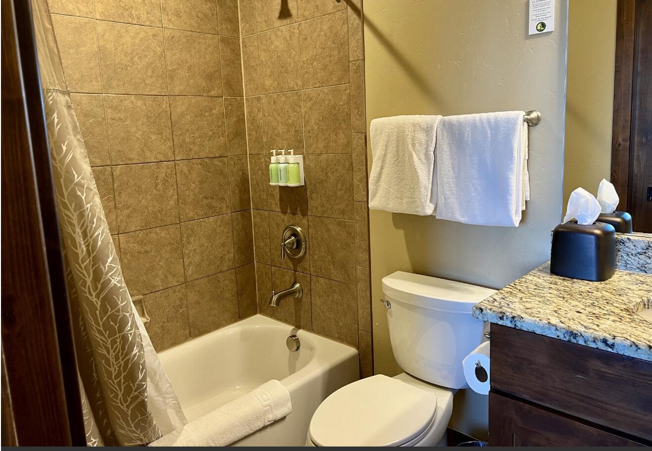 A bathroom with a bathtub, toilet, and a vanity with a countertop.