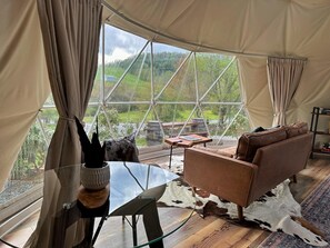 Una tenda con un tavolo in vetro, un divano in pelle e un tappeto in pelle di bovino.