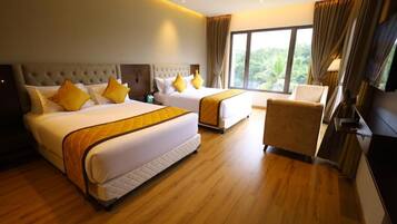 A hotel room with two beds, a chair, and a large window.